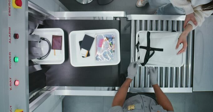 Diverse People, Travelers Putting Personal Items in Plastic Trays for X-ray Scanning on Conveyor Belt, TSA Worker Controlling Screening Procedure. Airport Security Check for Boarding Flight. Top View.