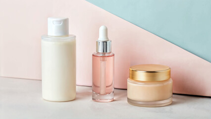 Skincare bottles on a minimal blue and pink set.