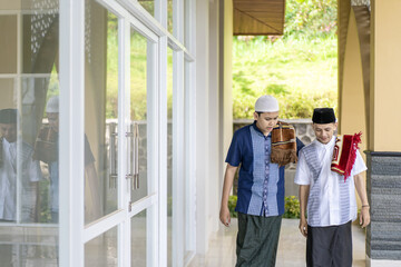 Young Men Shaking Hands Asking For Forgiveness During Hari Raya Celebration. men shaking hands, chatting, laughing during Lebaran