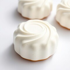 Elegant white mousse cakes with a delicate spiral design, perfect for a sophisticated dessert spread.
