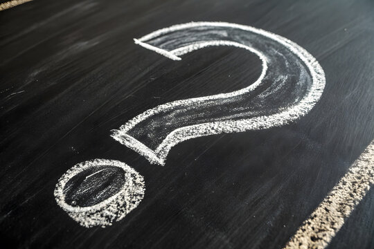 Large question mark drawn with white chalk on a blackboard, symbolizing curiosity, uncertainty, or education