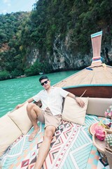 Happy man tourist in private longtail boat trip to koh Hong lagoon island at Krabi, Thailand....