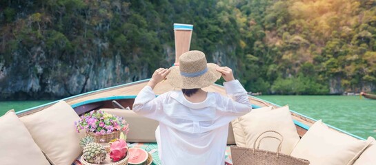 Happy Woman tourist in private longtail boat trip to koh Hong lagoon island at Krabi, Thailand....