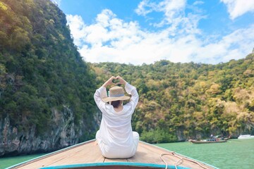 Happy Woman tourist in private longtail boat trip to koh Hong lagoon island at Krabi, Thailand....