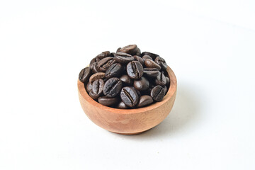 Close up view of roasted coffee beans in little wooden bowl isolated on white background. Clipping path.