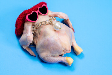 A fun, humorous dressed chicken wearing pink heart sunglasses and jewelry on a blue background....
