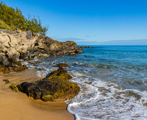 Waves Washing Over Boulders From Makaluapuna Point on Fleming Beach With Molokai Island Across...
