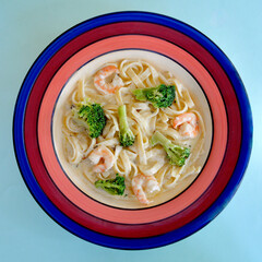 A closeup of garlic fettuccine with shrimp and broccoli.