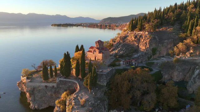 Aerial drone video of Saint John at Kaneo church overlooking Lake Ohrid in North Macedonia at sunset 