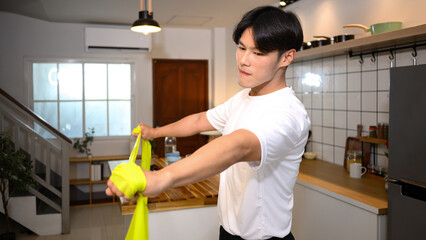 Young man athlete exercising with resistance band at home