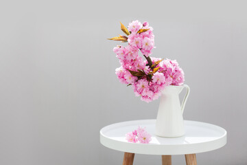 Cherry blossoms. Blooming tree branch. Spring bouquet of pink flowers from Japanese garden. Still life with sakura in vase on decorative table. Beautiful bunch in cozy home interior. Floral aesthetic