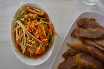 Somtam is Papaya Salad Thai. Made from chopped papaya served with grilled pork