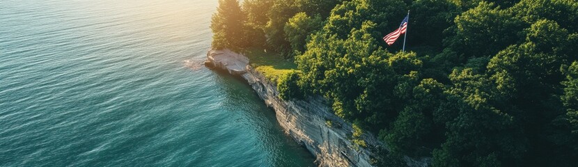 An American flag is flying on the cliff overlooking Lake Michigan, an aerial view captured by a drone.