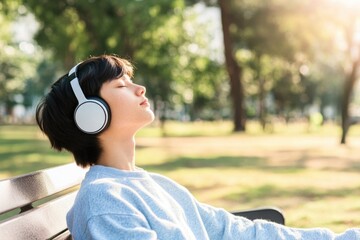 person sitting alone on park bench wearing headphones eyes closed lost in music with sunshine casting warm glow scene