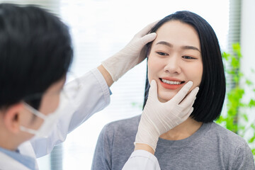 Dentist examining patient’s smile at a clinic during daylight hours in a modern setting