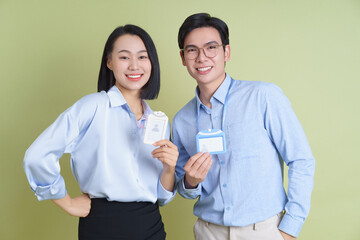 Young professionals posing with name badges in a bright green environment during a networking event