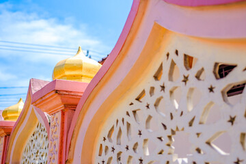 A close-up shot of an Islamic architectural structure featuring a decorative fence with intricate...