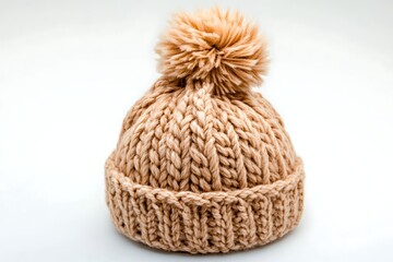 Beige knitted beanie with pompom, studio shot, winter accessory