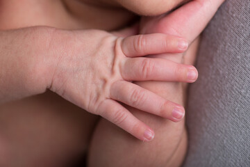 Newborn baby human little fingers and hands being held close up