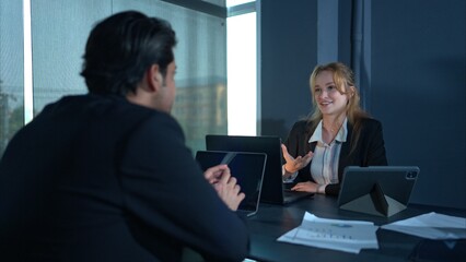 In the office, two businessmen and women discuss and exchange idea and give advice to each other to complete the work