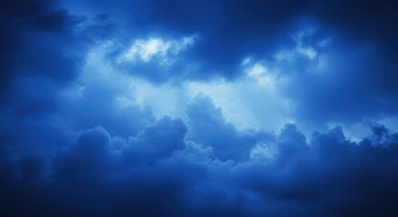 Obraz premium dark stormy sky, ominous clouds, deep blue hues, dramatic lighting, moody atmosphere, ethereal cloudscape, turbulent weather, foreboding sky, celestial landscape, high contrast, textured clouds, atmos
