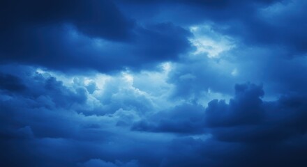 Obraz premium dark stormy sky, ominous clouds, deep blue hues, dramatic lighting, moody atmosphere, ethereal cloudscape, turbulent weather, foreboding sky, celestial landscape, high contrast, textured clouds, atmos