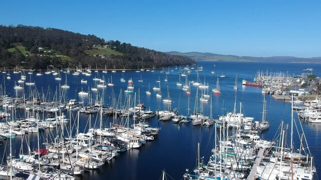 Aerial drone footage of Oyster Cove Marina and Little Kettering Marina, Bruny Island, Tasmania, showcasing boats, calm waters, scenic coastline, lush surroundings, and a tranquil harbor