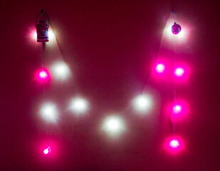 Burning New Year's garland on the wall in the shape of the letter M