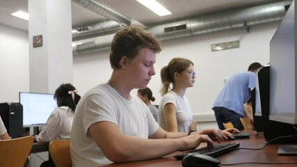 Portrait of male student at computer in university computer class