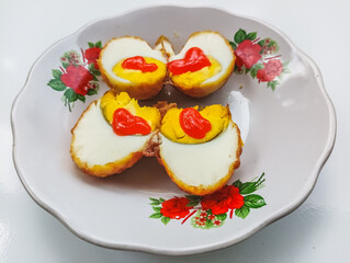 Fried eggs on a floral plate with chili sauce, delicious and savory breakfast food