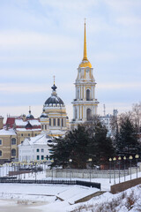 City of Rybinsk, Yaroslavl region, Russia. Winter view of the Transfiguration Cathedral and the Volga embankment. In the distance, a tall bell tower. Architectural landmarks. Traveling around Russia.