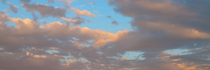 Obraz premium Beautiful sunset sky background with clouds. Scenic cloudscape. Wide panoramic background for design.