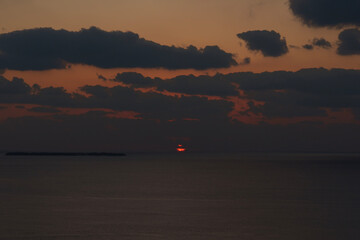 雲に隠れた沈む太陽