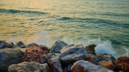 Sunlight of the sun in the morning reflection on the surface ocean with stone reef background.