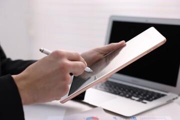 Electronic signature. Man using stylus and tablet at table, closeup