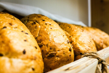 Fresh, freshly baked round bread with seeds on a bakery shelf