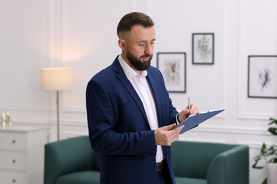 Real estate appraisal. Inspector with clipboard conducting property valuation indoors