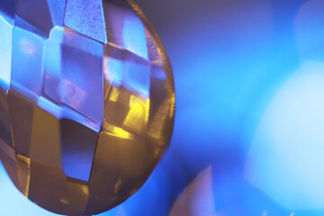Macro Photography of Faceted Crystal with Blue and Yellow Light Reflections