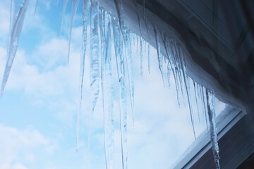 Icicles Hanging from Roof on a Cold Winter Day with Clear Blue Sky
