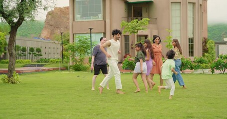 Indian happy family group play game running with cute son kid boy enjoy day outdoor home park Adult mom dad man woman young male female teen girl child have fun joy spend time at outside garden house - Powered by Adobe