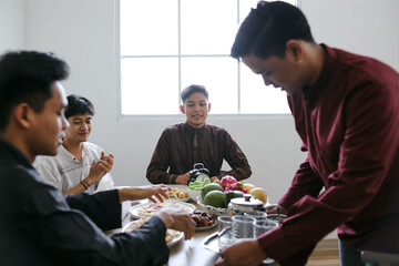 Asian Muslim Man Serving Drinks For His Friends To Break Fasting Together During Ramadan Kareem at Home