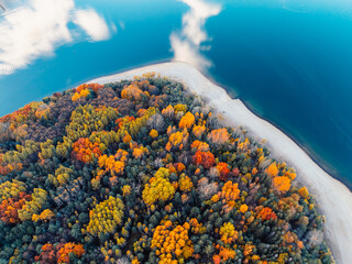 Fototapeta premium Liptov region with Tatras mountains around. Liptovska mara dam landspace. autumn deciduous forest view from above