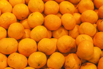 Bunch of delicious fresh tangerines or oranges on market display with no label, ready for sale.