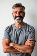 Obraz premium Portrait of smiling bearded man with crossed arms on white background