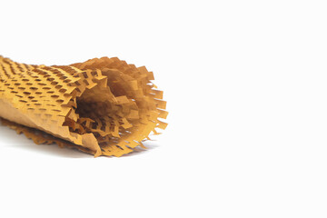 Close up of a roll of honeycomb paper wrap isolated on a white background. Brown package wrapping paper. Copy space for text. For graphic design or banner background