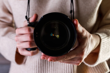 Professional photographer woman holding camera in your hands.