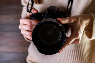 Professional photographer woman holding camera in your hands.