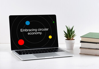 Laptop showing circular economy concept with orbiting planets