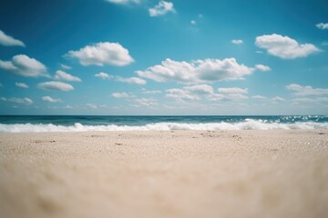 Fototapeta premium Sunny beach scene with ocean waves and fluffy clouds