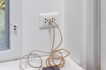 Mobile device are charging on USB wall socket.